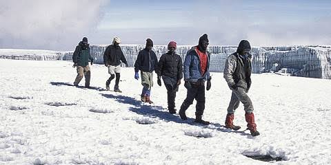 Hikers resting at a mountain hut camp on the Mount Kilimanjaro Marangu Route trek